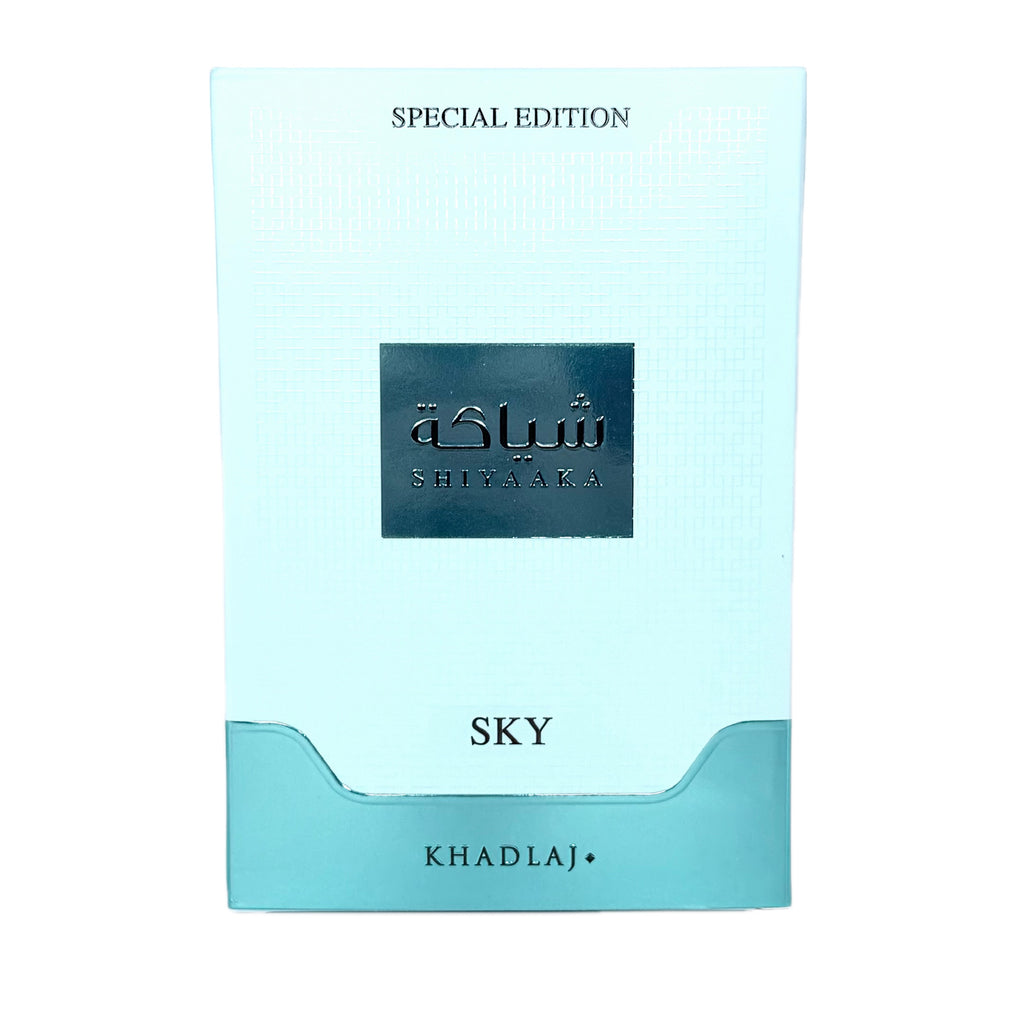 A light blue and turquoise card packaging for Shiaaaka 'SKY' special edition by KhadlaJ, featuring a dark metallic blue central label with Arabic and English text.